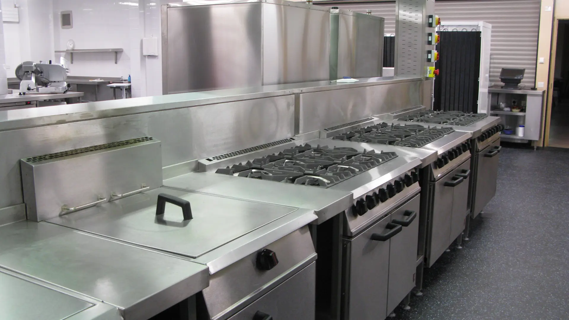 Stainless steel commercial catering gas ranges in a professional kitchen