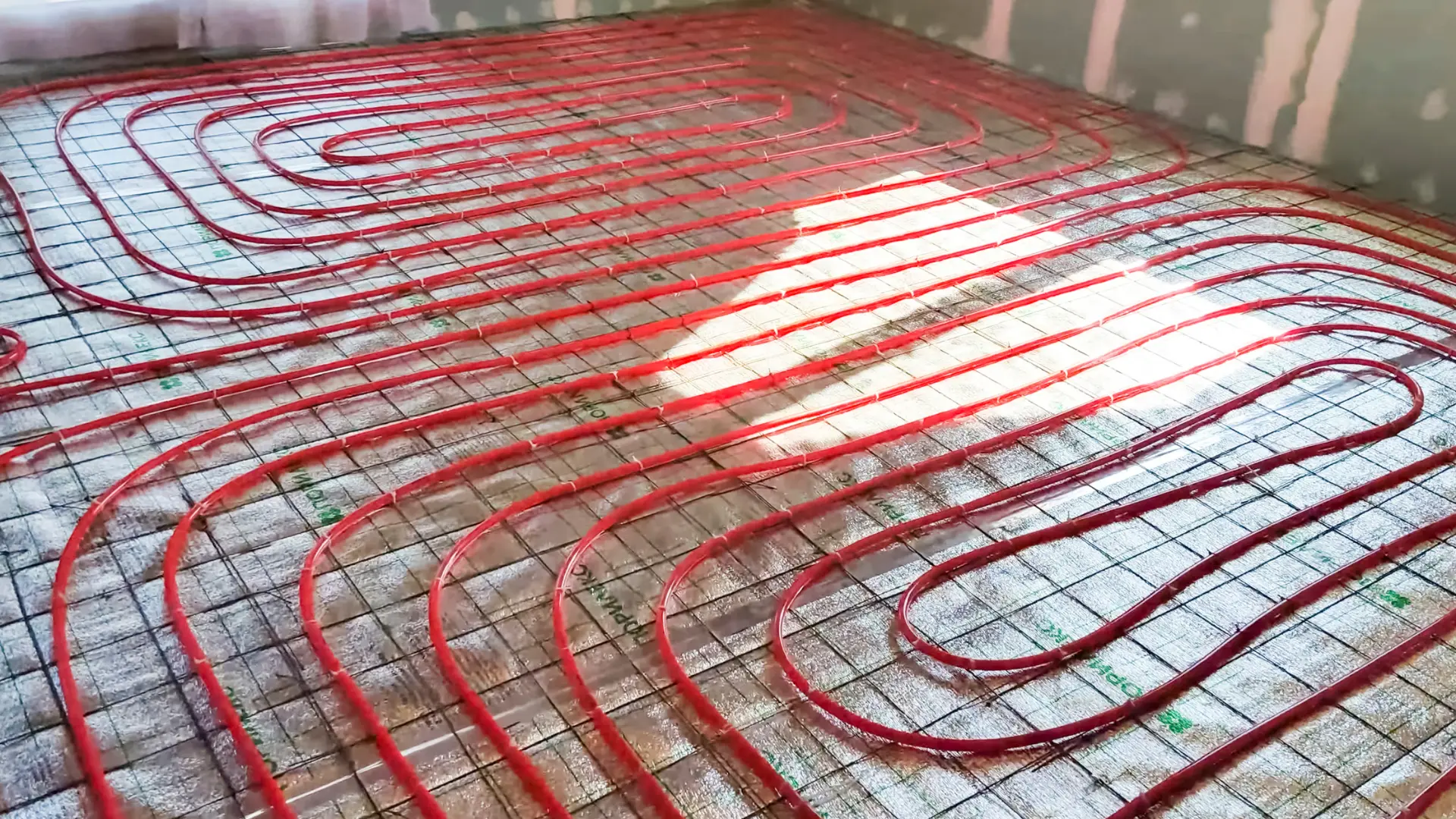 Underfloor heating circuits laid across a floor before screeding